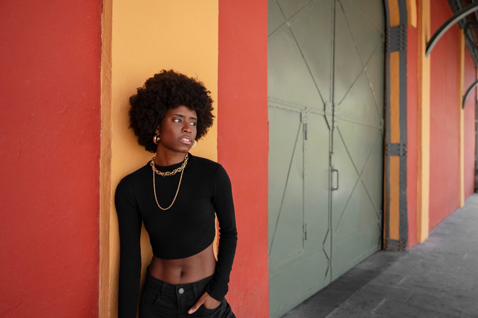 une femme noir entrain de poser sur un mûr